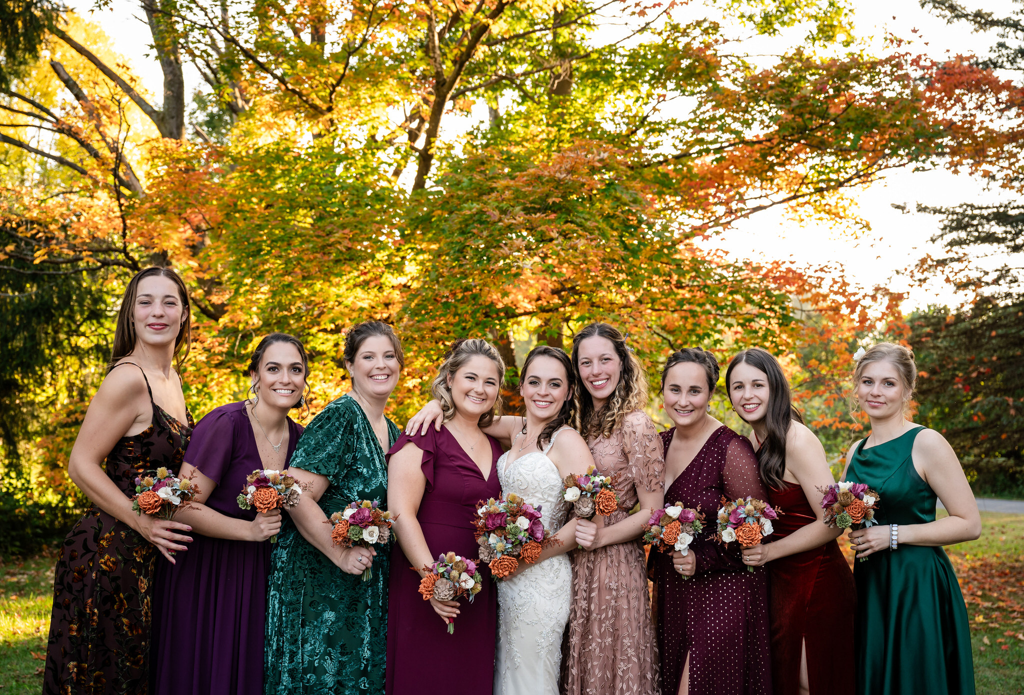 Autumn wedding party gathered with colorful bouquets